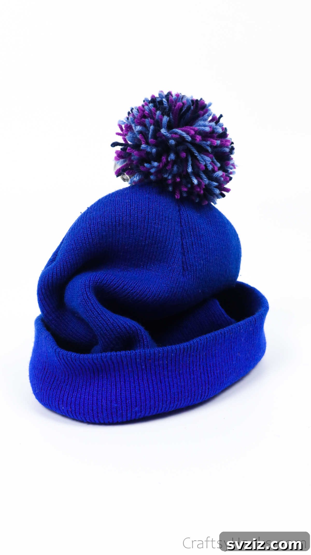 Beanie hat adorned with a fluffy pink yarn pom pom