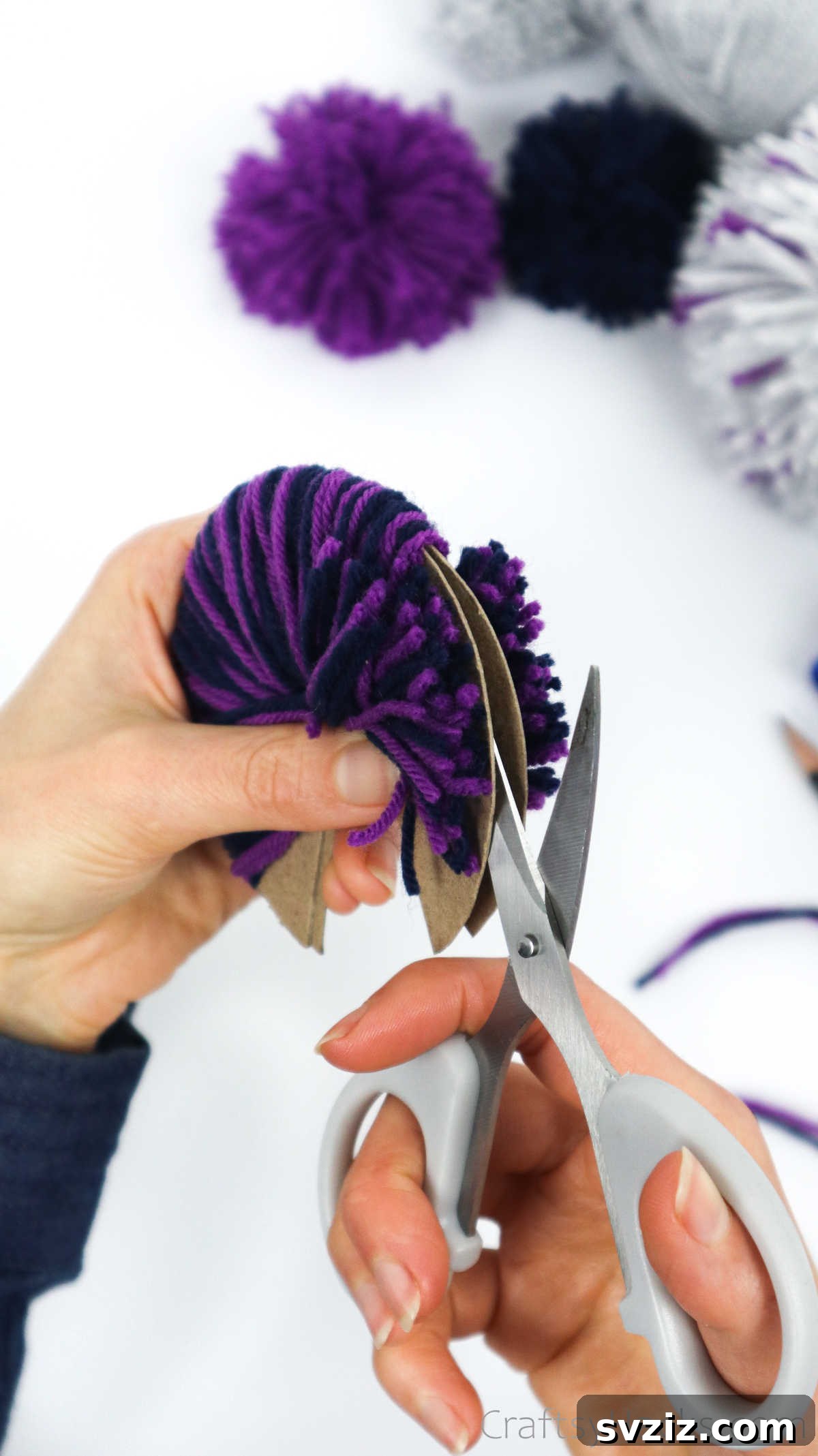 Cutting through the wrapped yarn between the two cardboard disks