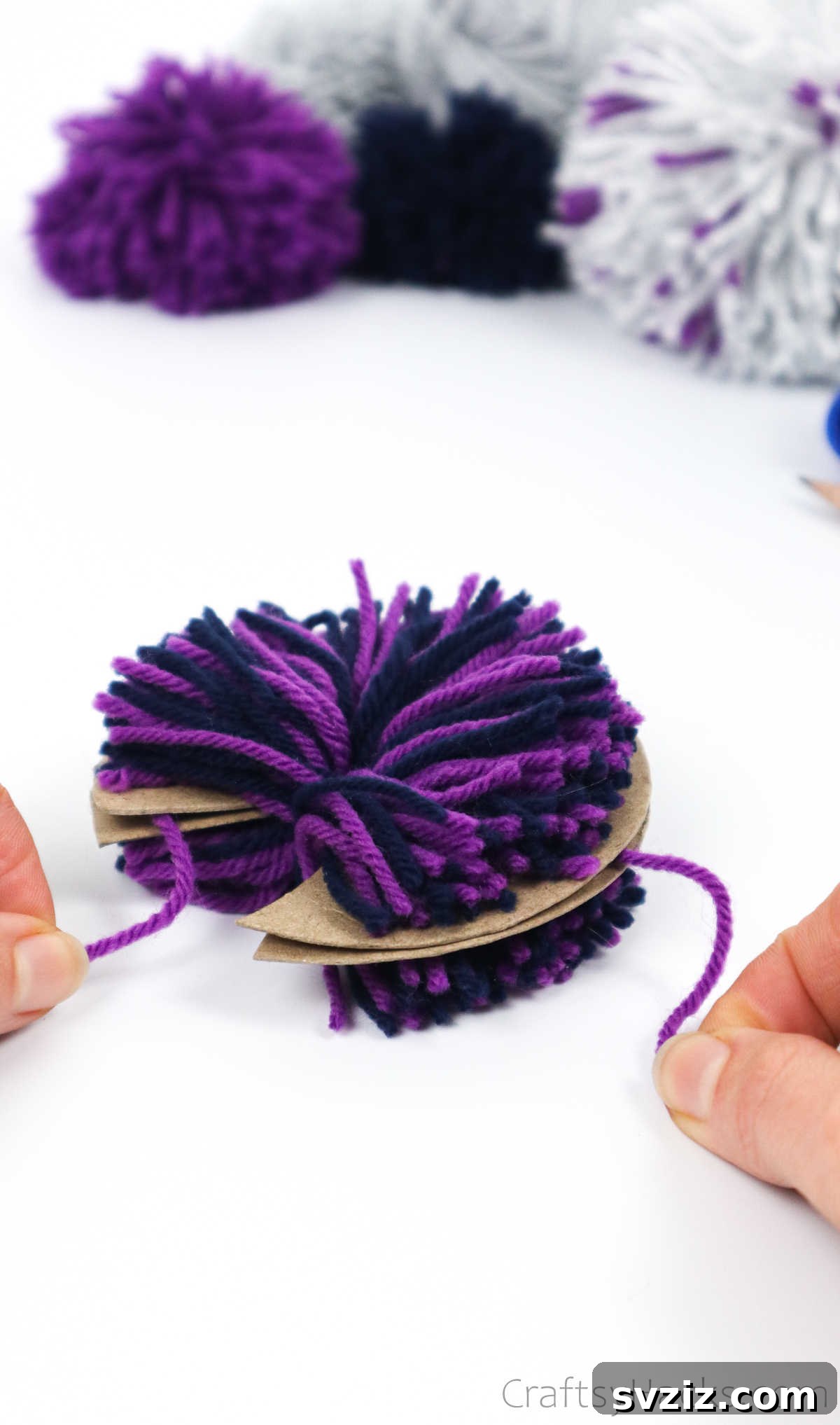 Sliding a tie-off yarn strand between the two cardboard disks