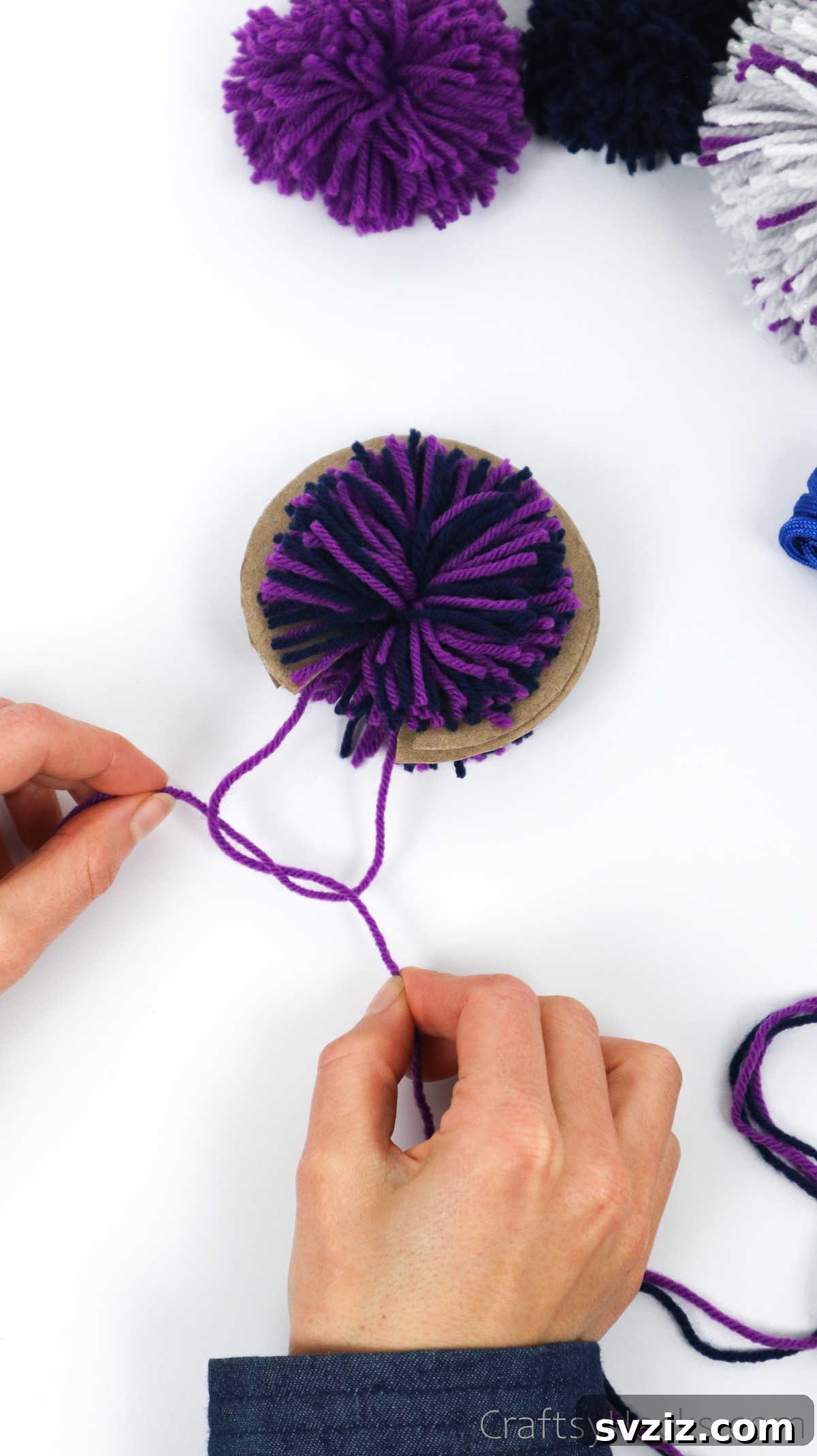 Tying a double knot around the center of the yarn bundle