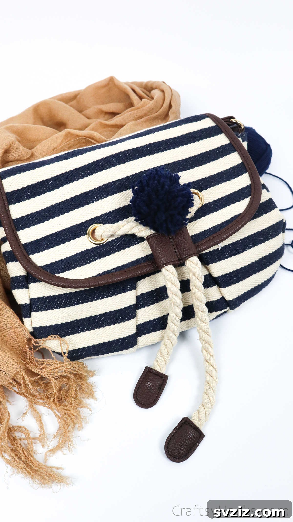 Elegant handbag accented with a charming pink yarn pom pom