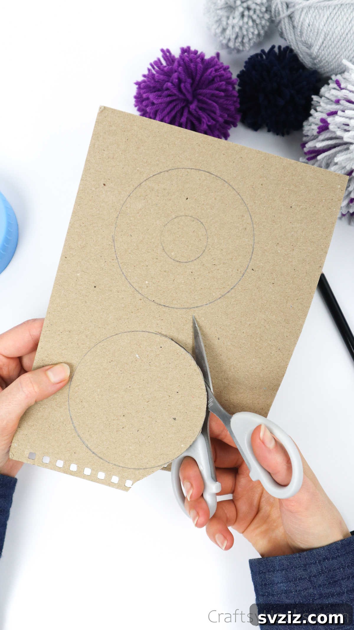 Cutting out the larger cardboard circle using scissors