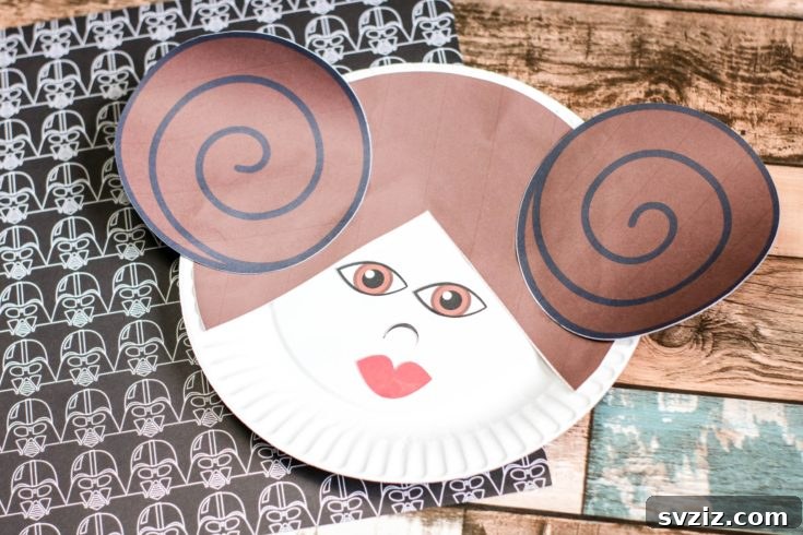 Crafting Smiles: Paper Plate Fun for Kids 18 Iconic Princess Leia paper plate craft with her signature bun hairstyle and determined expression.
