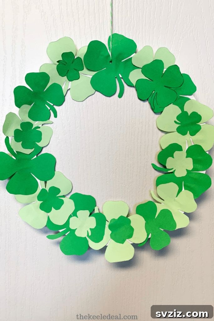 Crafting Smiles: Paper Plate Fun for Kids 25 Festive paper plate St. Patrick's Day wreath adorned with various shades of green four-leaf clovers.