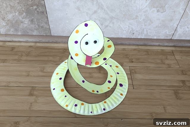 Crafting Smiles: Paper Plate Fun for Kids 28 Coiled paper plate snake craft with painted patterns, googly eyes, and a forked tongue.