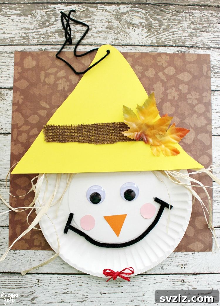 Crafting Smiles: Paper Plate Fun for Kids 29 Adorable paper plate scarecrow craft with a straw hat, patchwork details, and a cheerful smile, ideal for Thanksgiving.