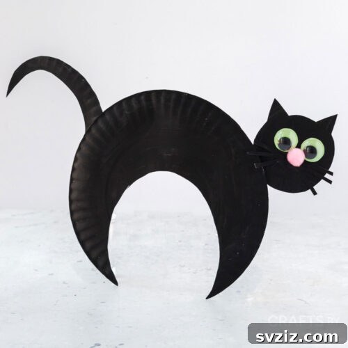 Crafting Smiles: Paper Plate Fun for Kids 38 Sleek paper plate black cat craft with pointed ears, green eyes, and whiskers, perfect for Halloween decor.