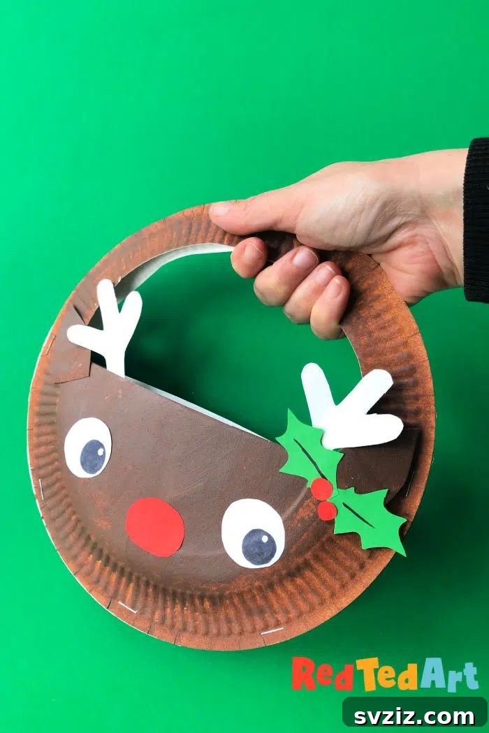 Crafting Smiles: Paper Plate Fun for Kids 44 Cute paper plate reindeer purse with a red nose, antlers, and a functional string handle.