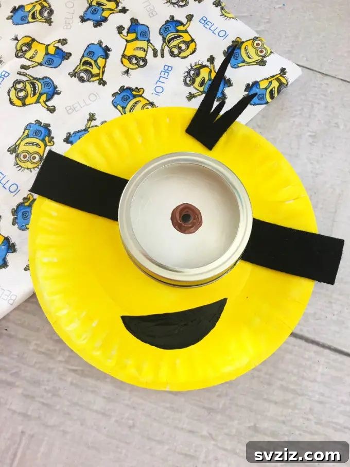 Crafting Smiles: Paper Plate Fun for Kids 45 Cheerful paper plate Minion craft with its signature yellow body, goggle eye, and denim overalls.