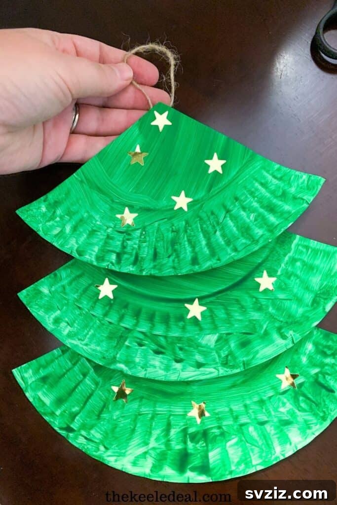 Crafting Smiles: Paper Plate Fun for Kids 47 Simple paper plate Christmas tree craft decorated with colorful pom-poms and a star topper.