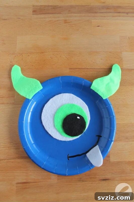 Crafting Smiles: Paper Plate Fun for Kids 9 Googly-eyed paper plate monster craft with colorful felt features and pipe cleaner horns, perfect for kids.
