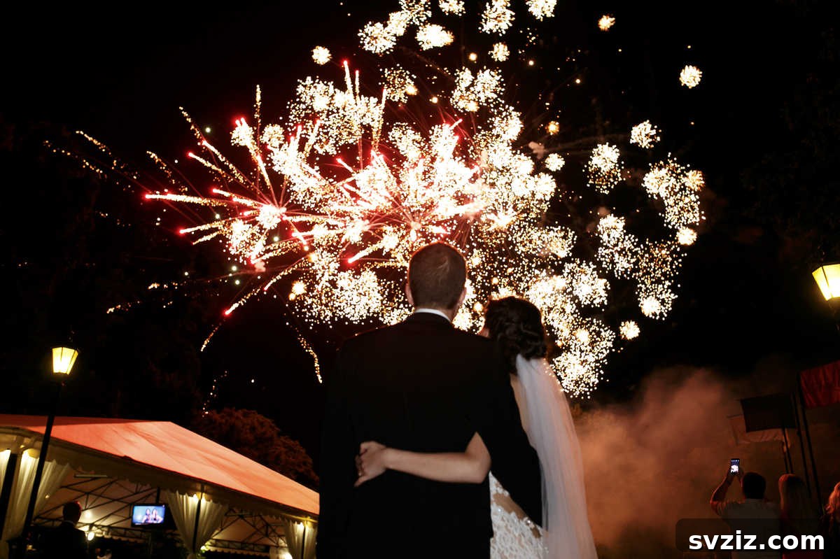 A wedding couple standing under a spectacular fireworks display