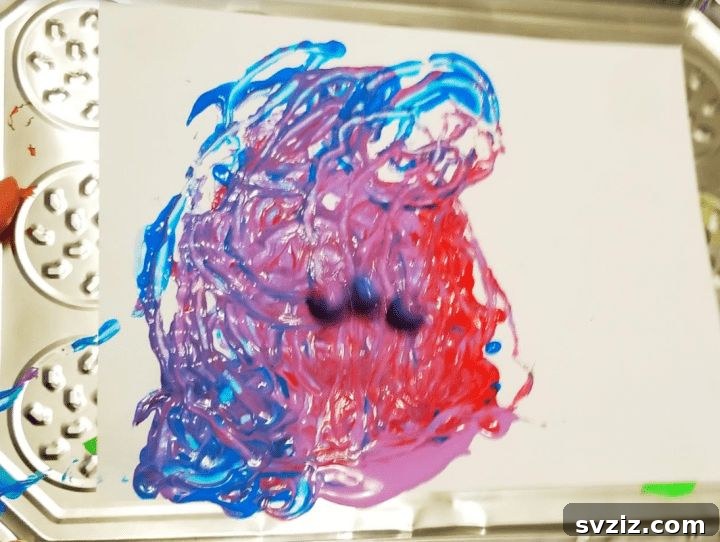 Abstract art created by moving magnets under a tray with paint blobs, a fun and educational activity for children.