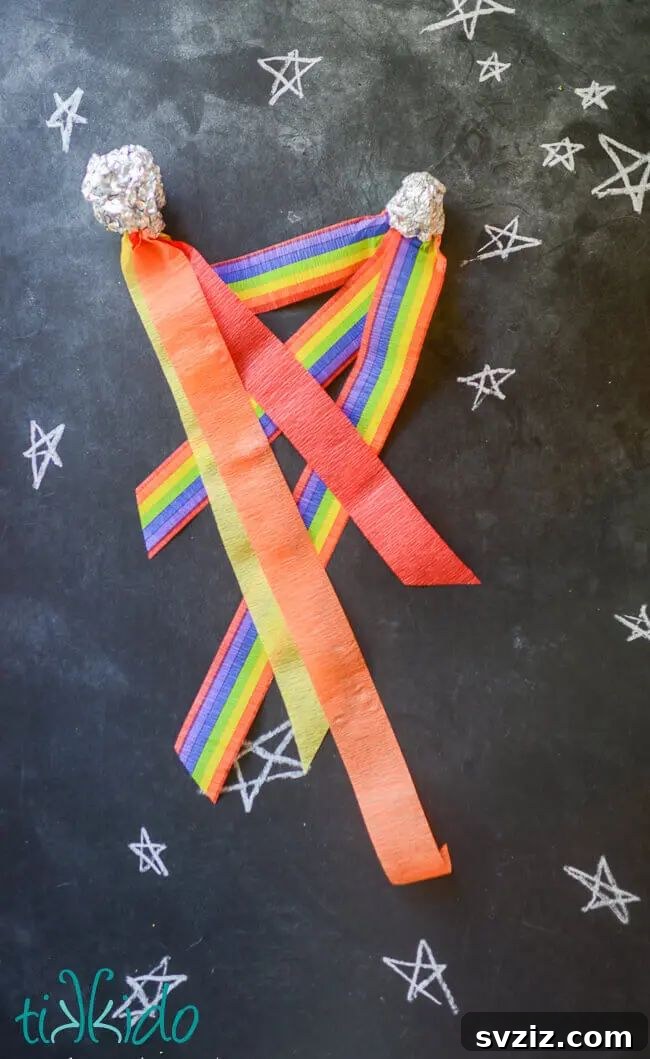 Colorful comet craft made with foil sheets and crepe paper strips, a simple DIY toy for imaginative play.