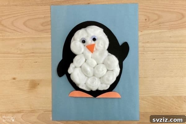 A charming cotton ball penguin craft with googly eyes, perfect for young children to create.