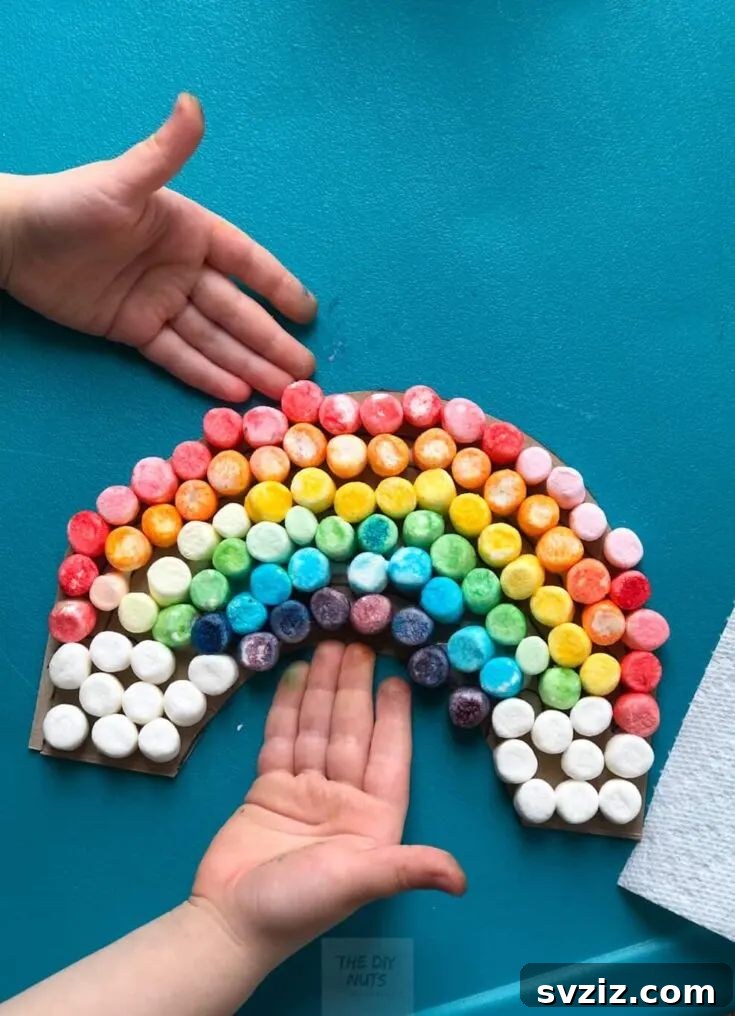 A colorful rainbow craft made with marshmallows on cardboard, perfect for teaching colors to toddlers and preschoolers.
