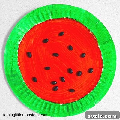 A colorful paper plate watermelon craft with green rind, red fruit, and black bean seeds, perfect for summer.