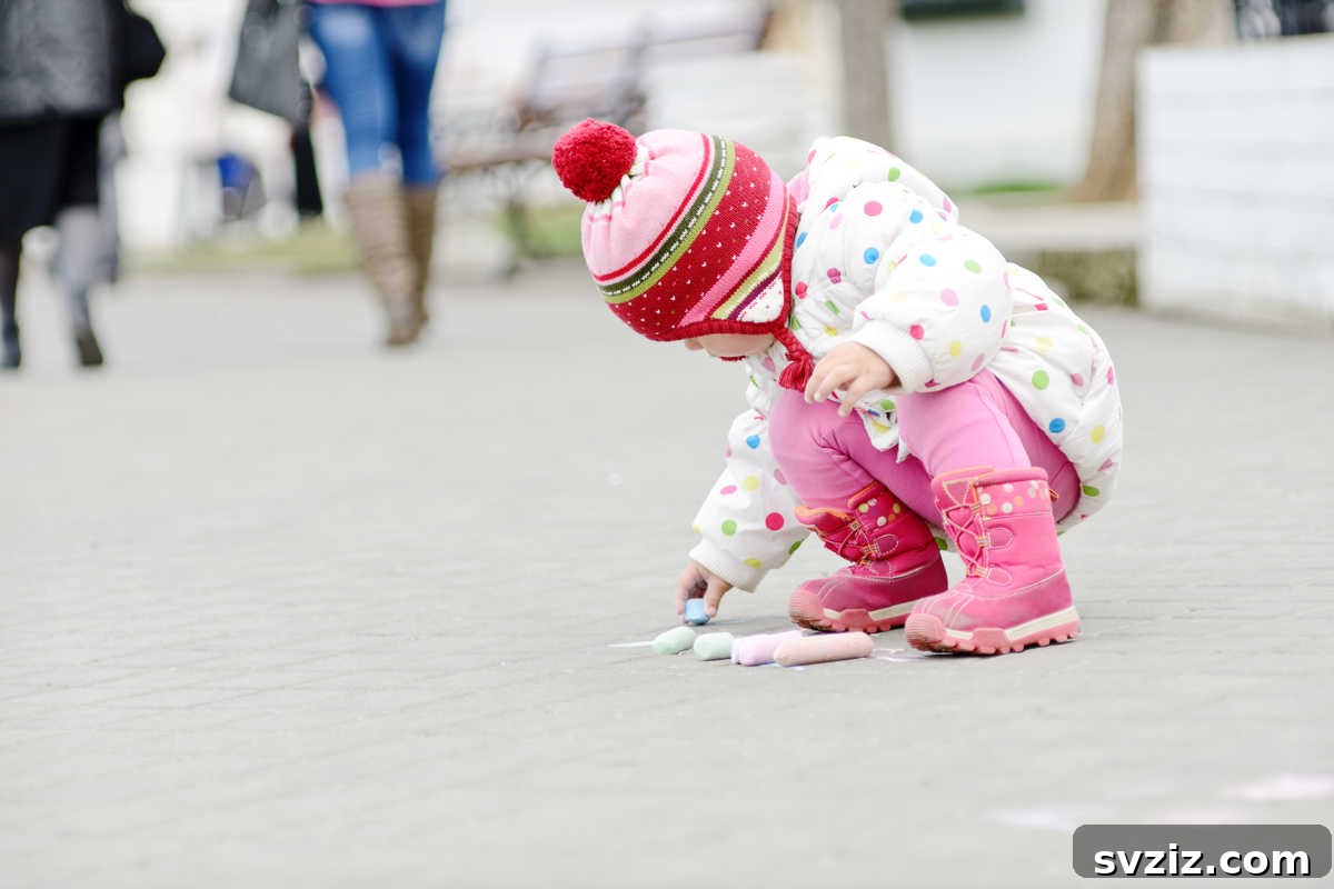 41 Creative Play Ideas for Two-Year-Olds 3 A child drawing vibrant designs on a sidewalk with colorful chalk.