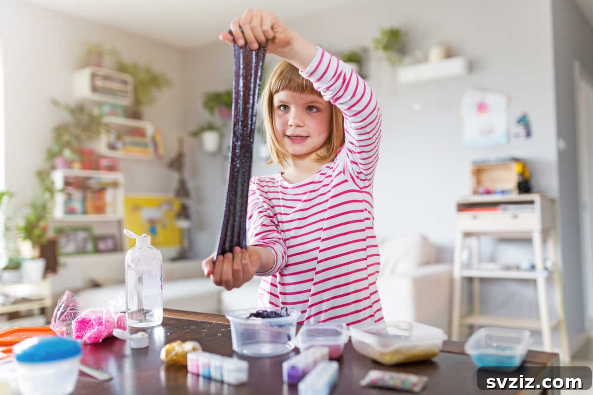 41 Creative Play Ideas for Two-Year-Olds 21 A child's hands stretching vibrant, colorful slime during sensory play.