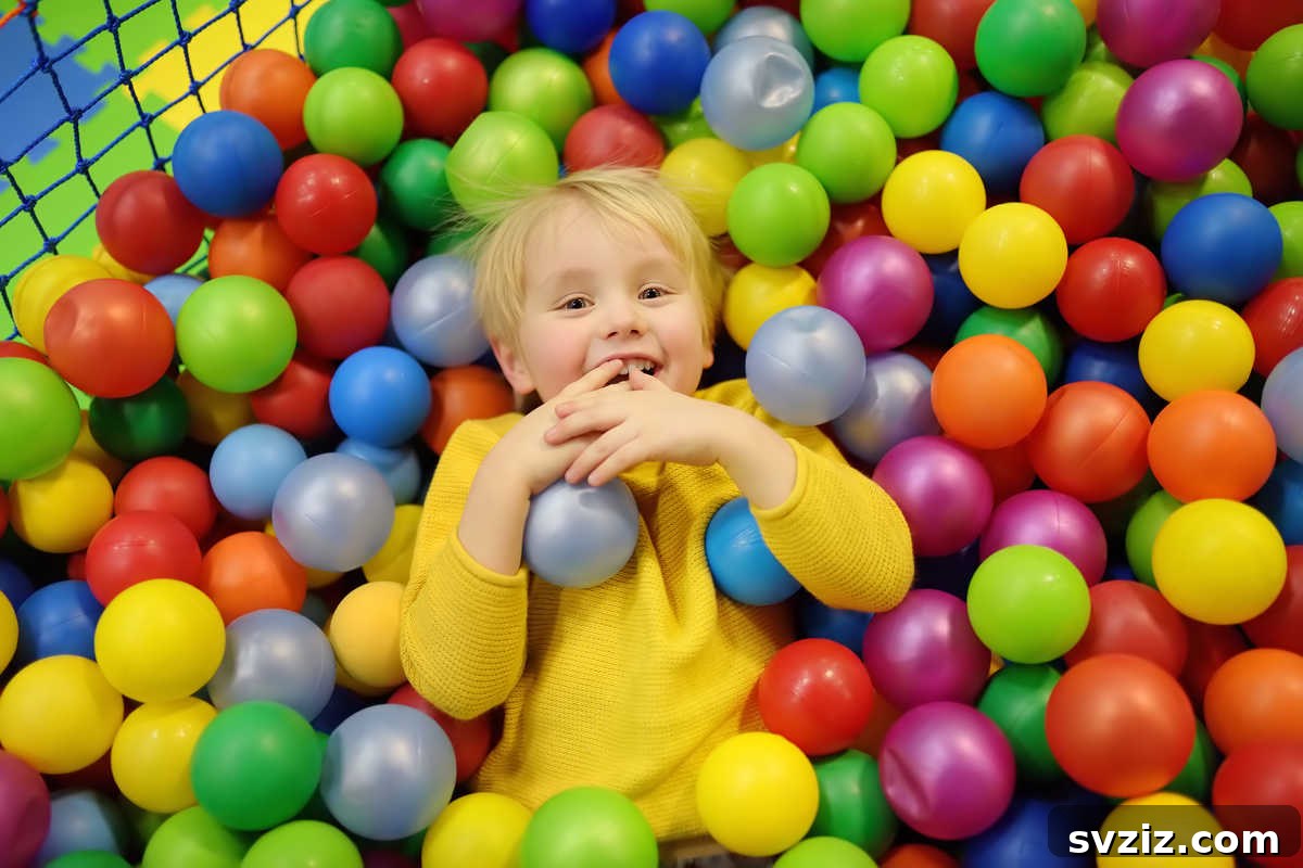 41 Creative Play Ideas for Two-Year-Olds 25 A toddler gleefully playing in a colorful ball pit filled with plastic balls.