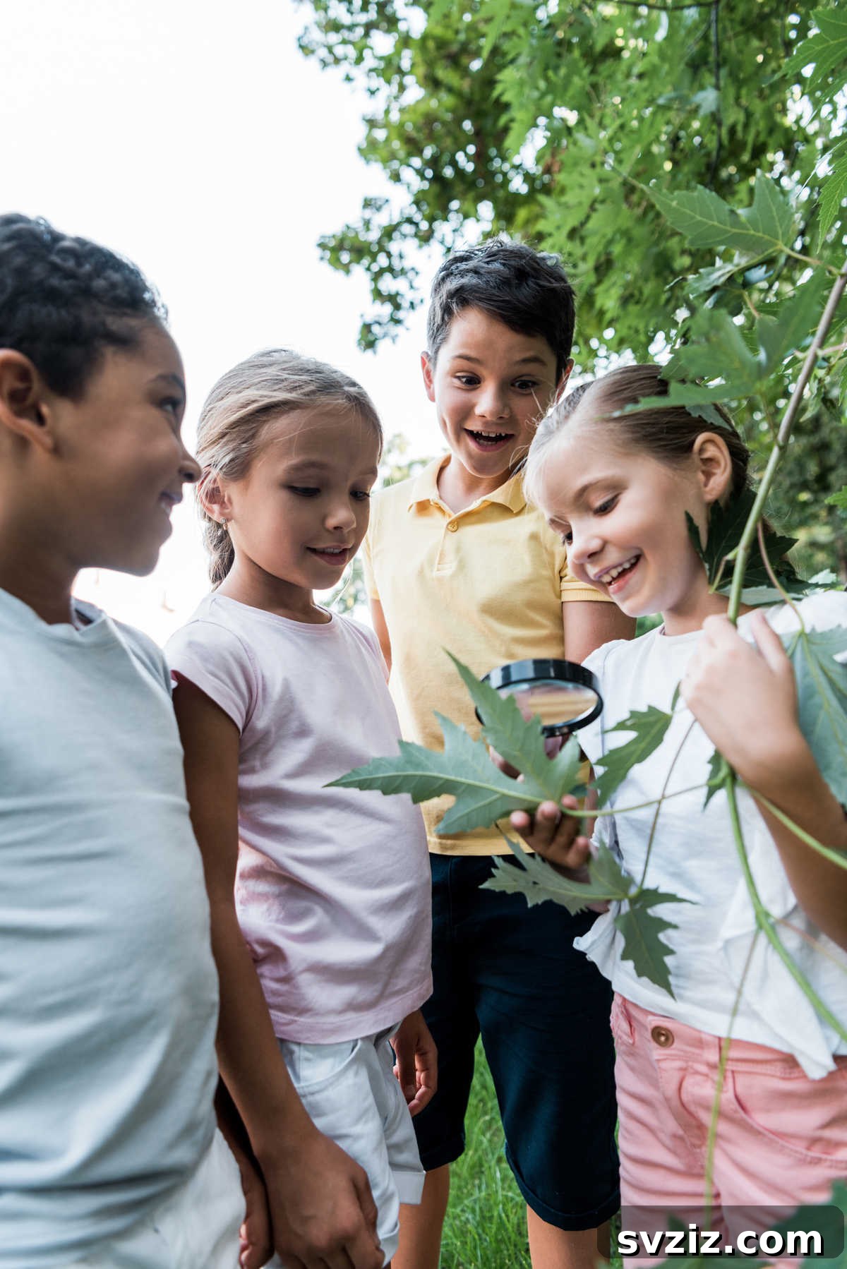 Child looking through a magnifying glass at a small bug on a leaf, during a bug scavenger hunt.