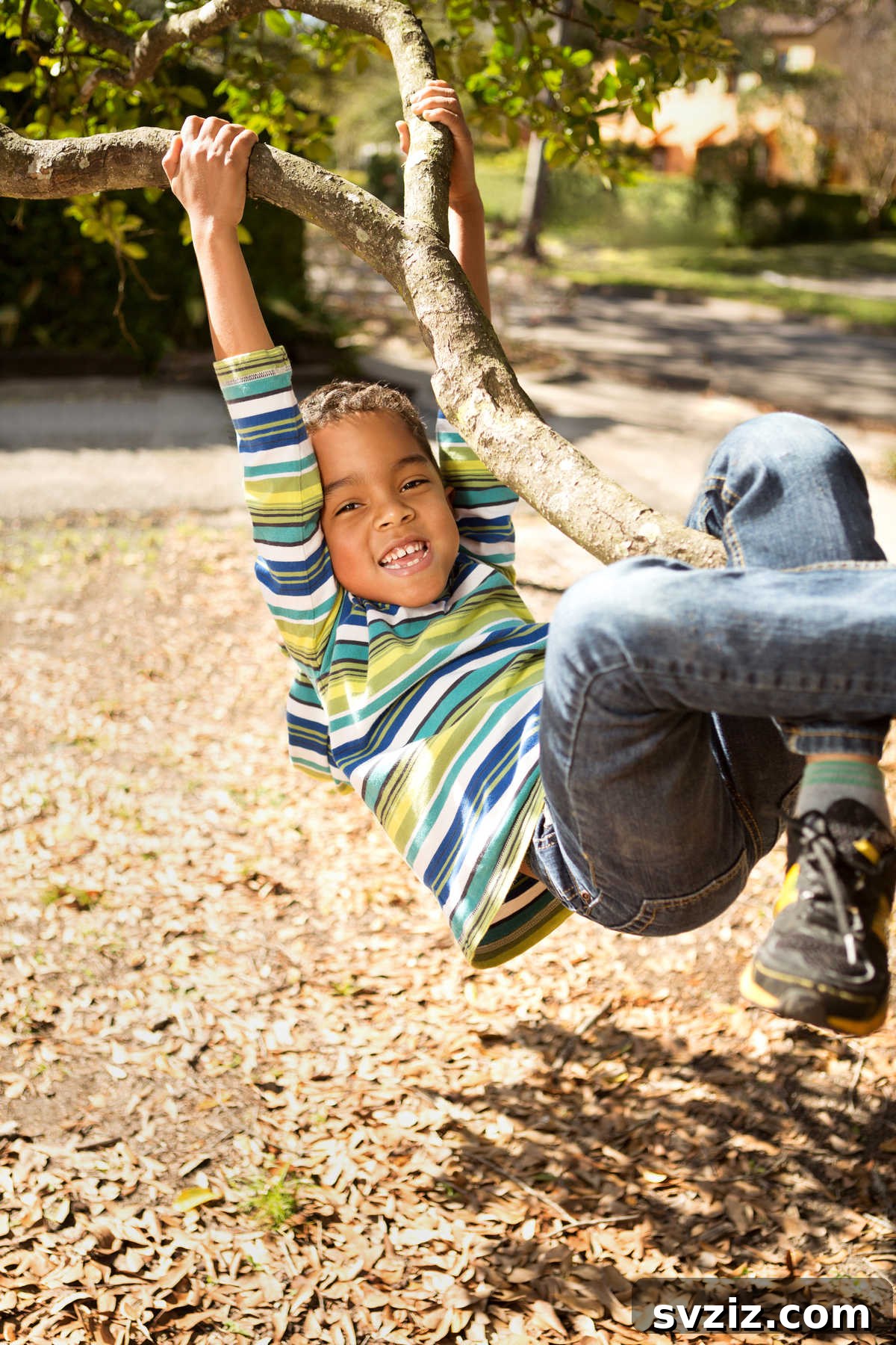 Boy confidently climbing a large tree, showcasing physical strength and adventurous spirit.