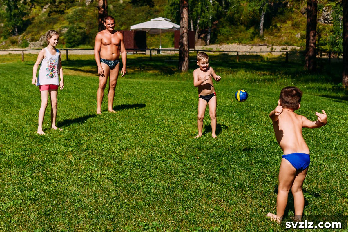 Group of boys playing an energetic game of dodgeball on a grassy field, a classic fun outdoor game.