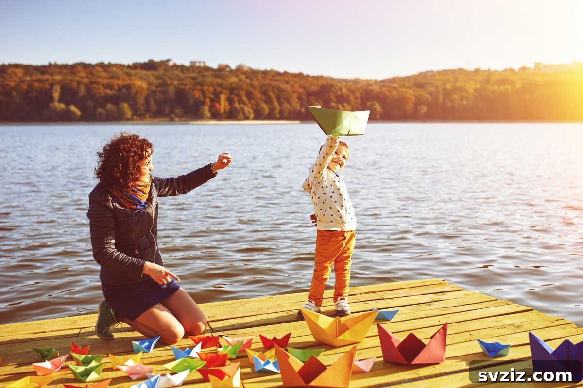 Child blowing through a straw to race paper boats in a small stream or puddle, a simple and fun outdoor game.