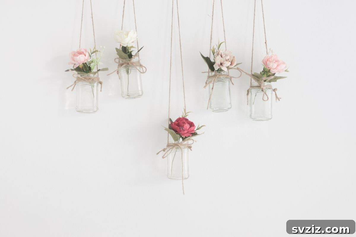 Glass jars with fresh flowers suspended from a dorm wall, adding natural beauty and freshness to the room.