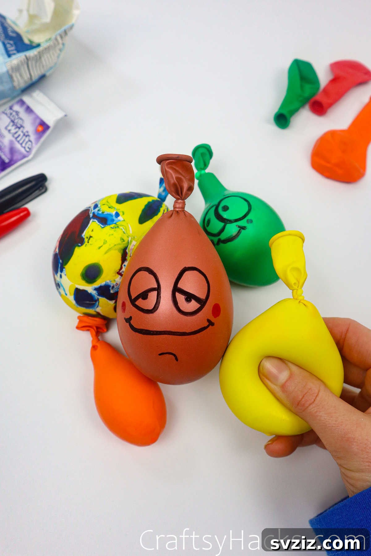 Craft Your Calming Stress Ball 2 Hands holding three colorful DIY stress balls made from balloons