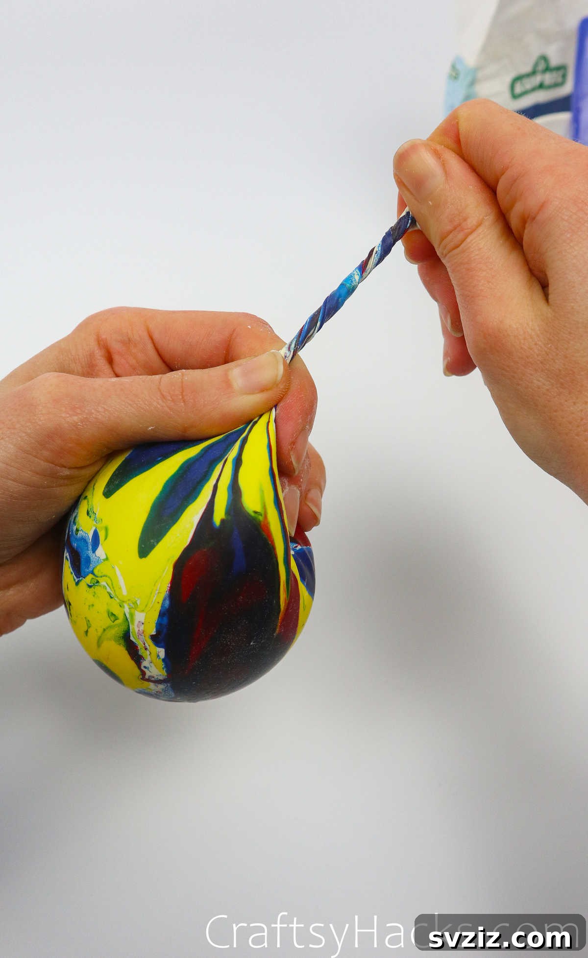 Craft Your Calming Stress Ball 21 Hand carefully pulling the filled balloon off the plastic bottle funnel