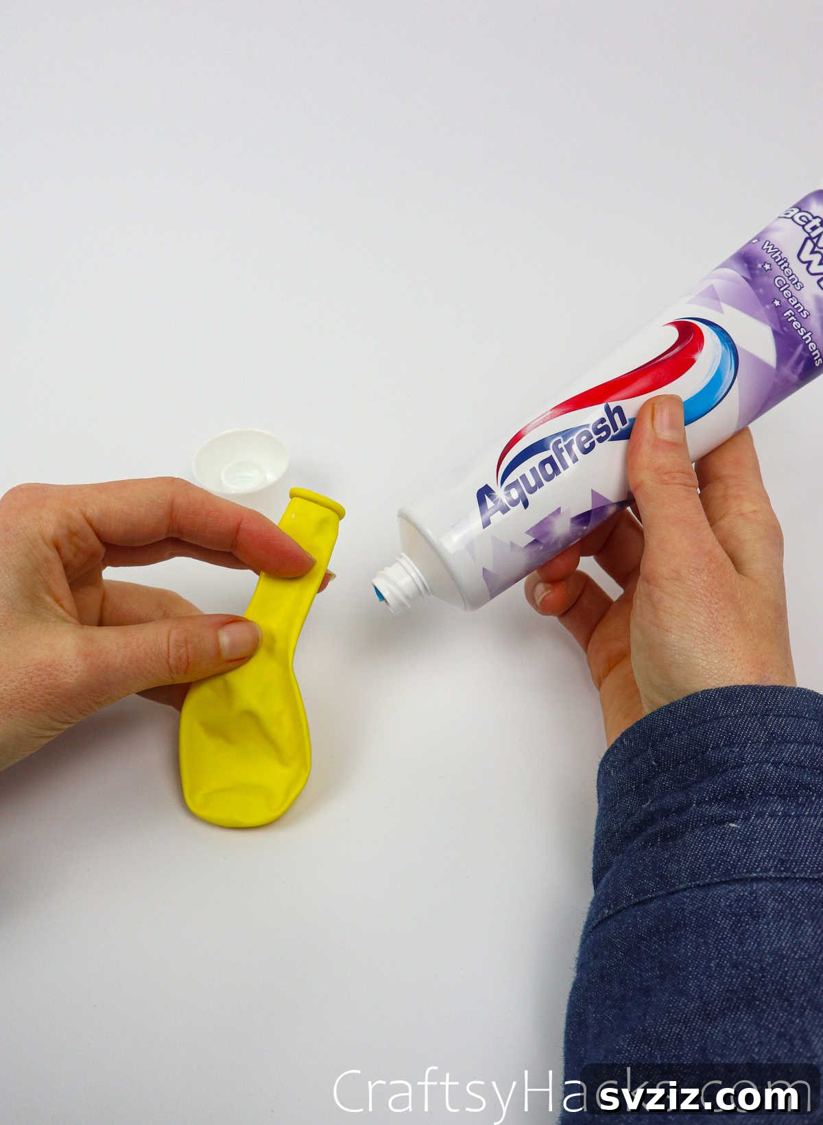 Craft Your Calming Stress Ball 24 Hand holding a tube of toothpaste, ready for the stress ball hack