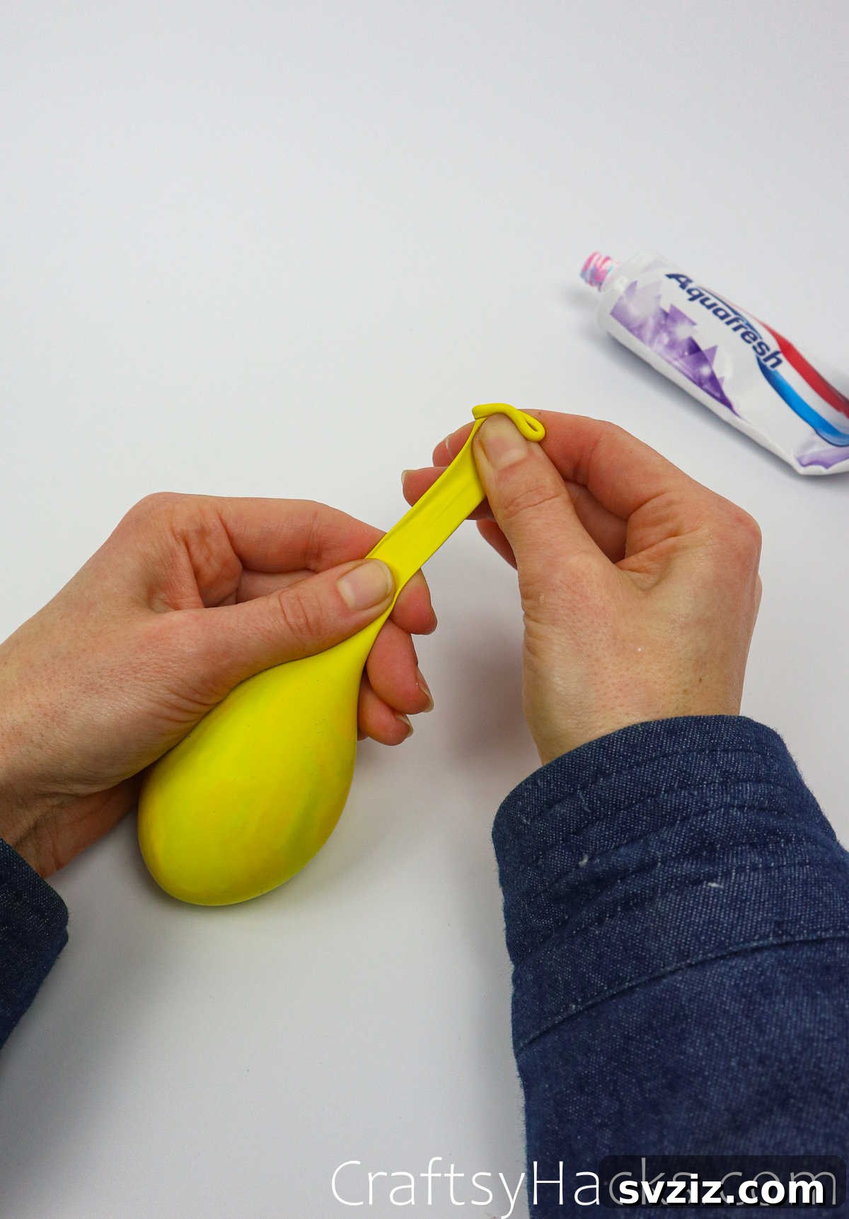 Craft Your Calming Stress Ball 27 Hand holding a balloon filled with toothpaste, ready to be tied