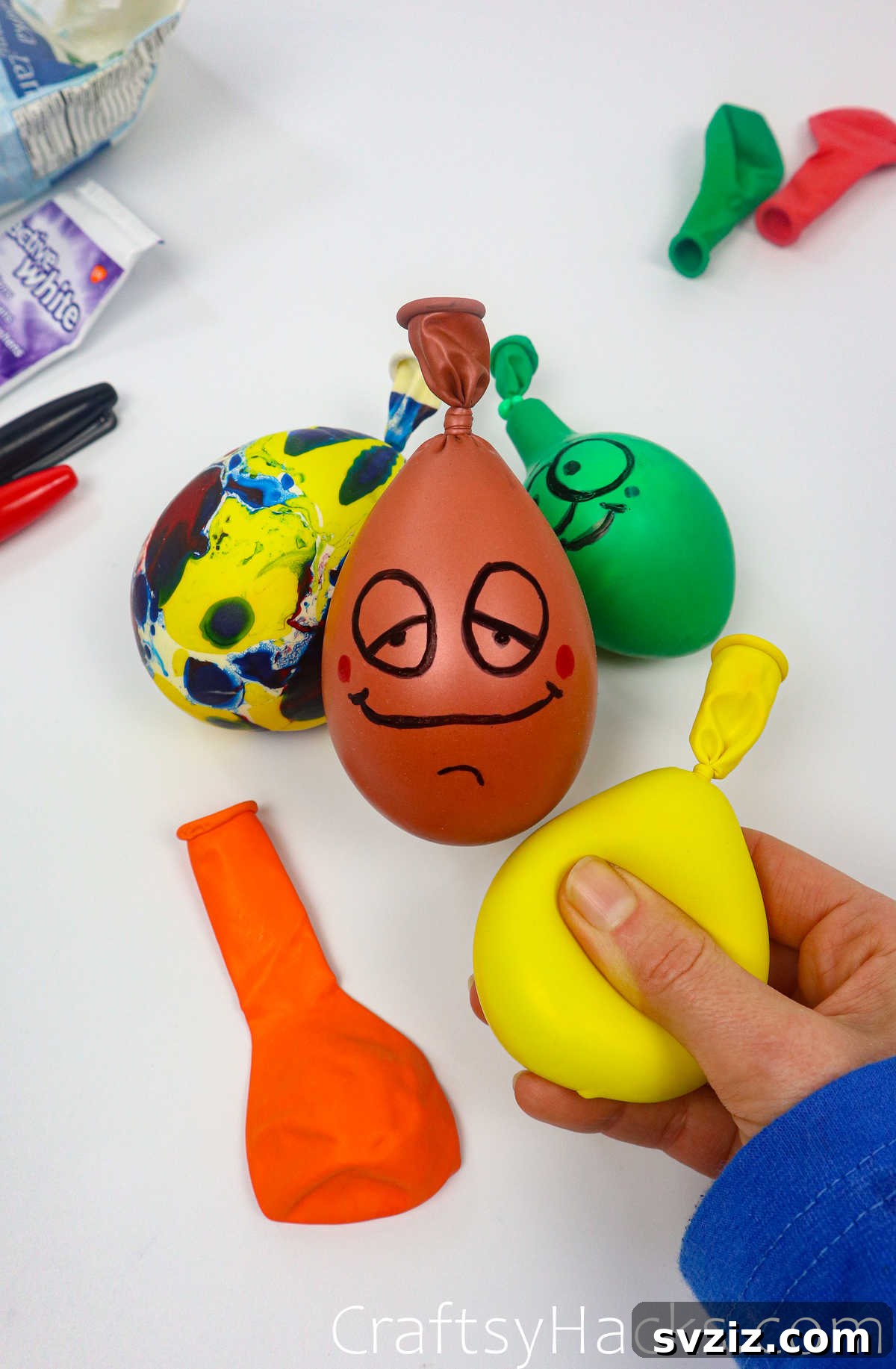 Craft Your Calming Stress Ball 4 Hand gently holding a yellow DIY stress ball with a drawn face