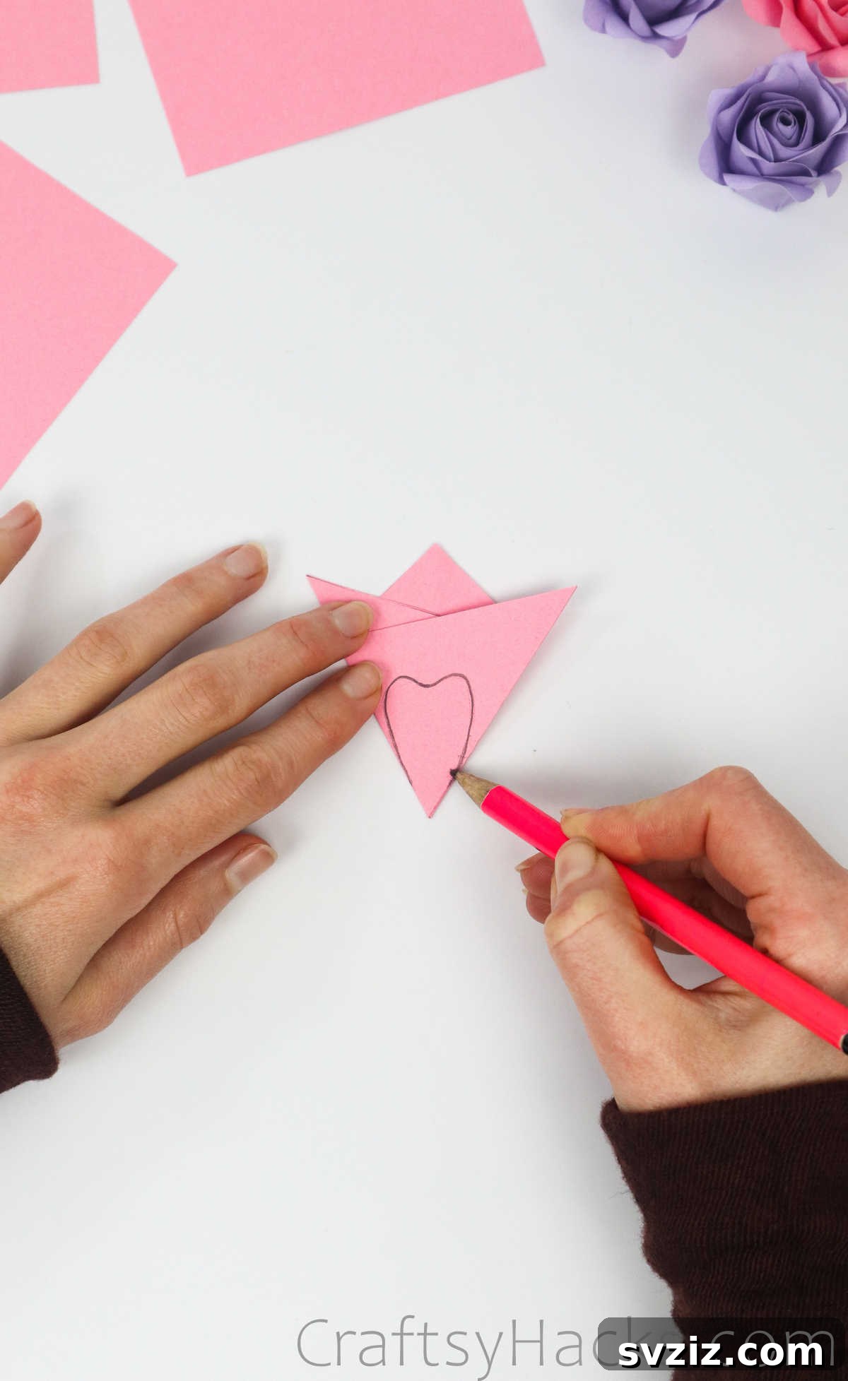 Your Simple Guide to Gorgeous Paper Roses 12 A petal shape is drawn with a pencil on the folded pink paper, ready for cutting