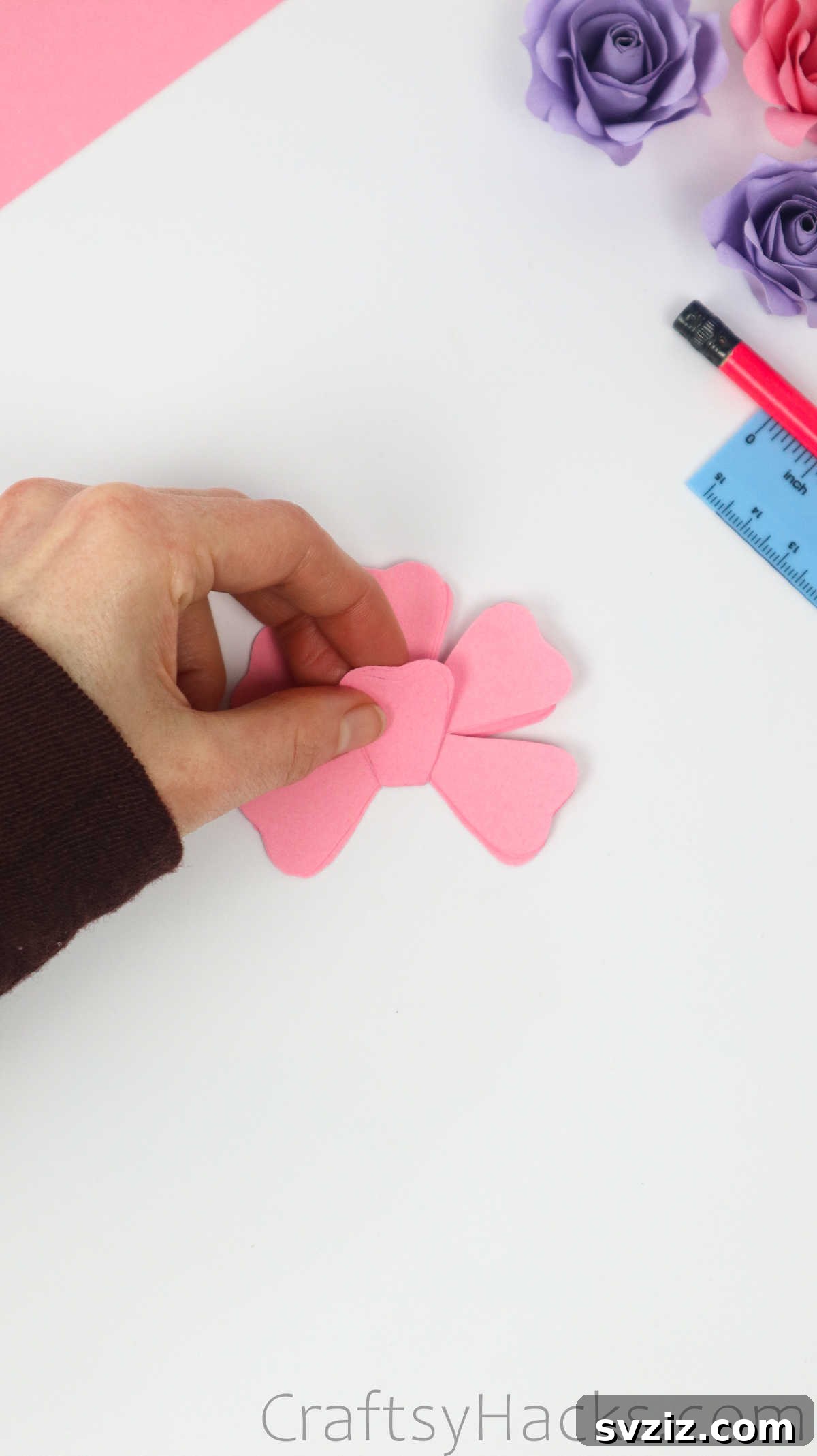 Your Simple Guide to Gorgeous Paper Roses 19 A petal from the stacked paper flowers is gently folded inward to create a crease