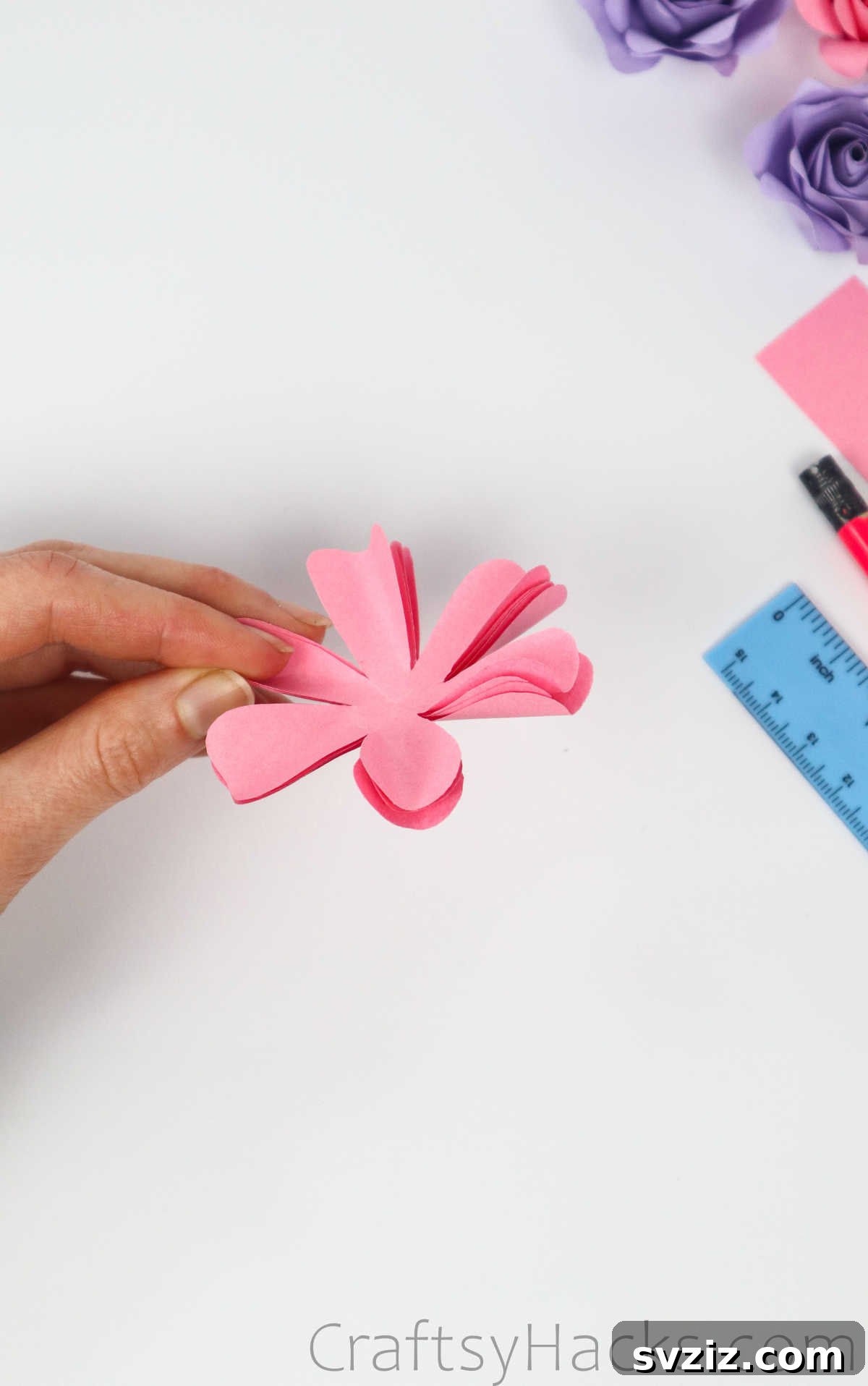 Your Simple Guide to Gorgeous Paper Roses 22 Close-up of a paper petal after being curved with a wooden skewer, showing its soft, realistic shape