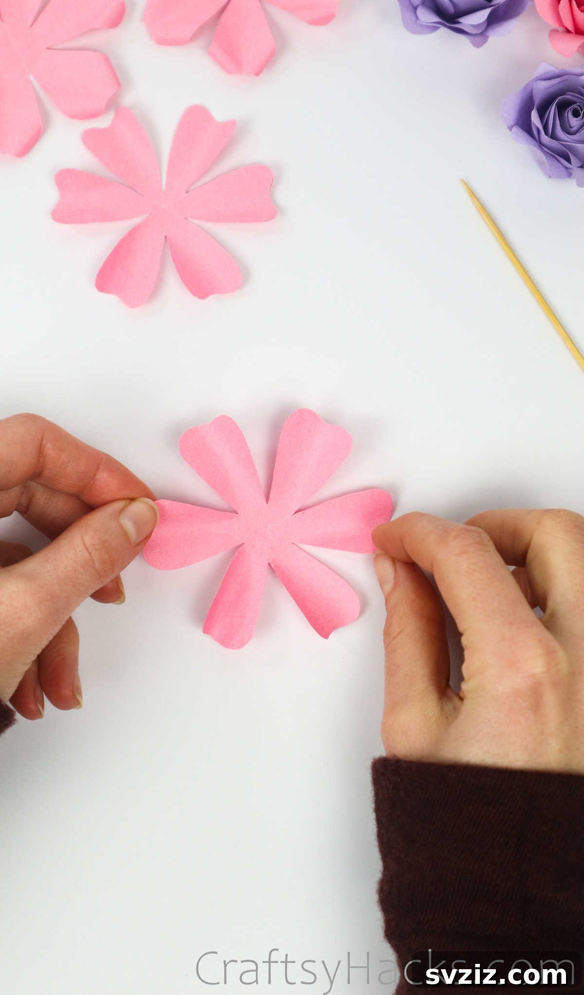 Your Simple Guide to Gorgeous Paper Roses 27 A hand holding one of the toothpick-curled paper flower pieces, showcasing its soft edges