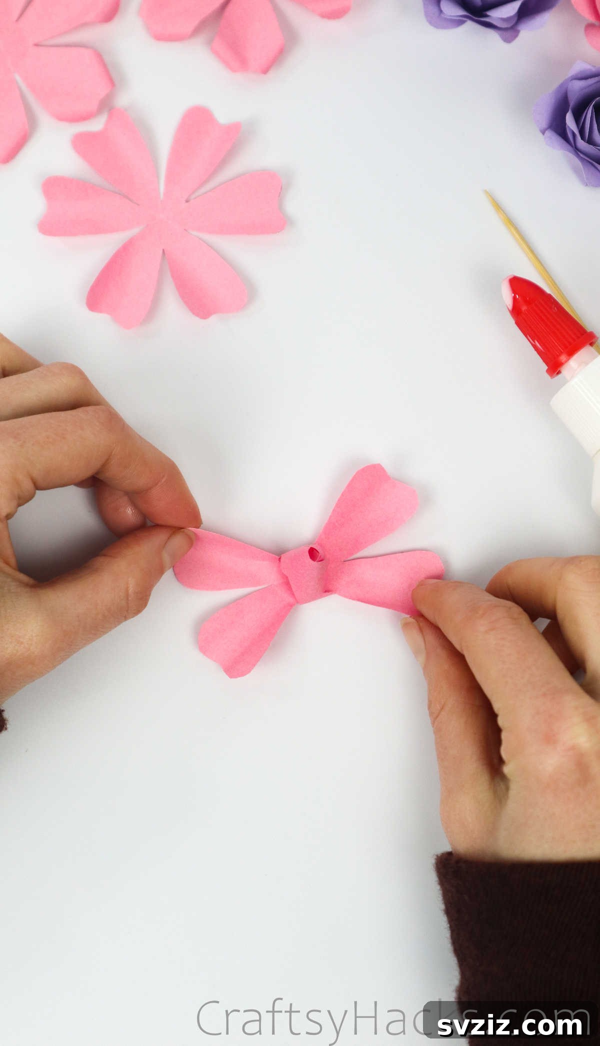 Your Simple Guide to Gorgeous Paper Roses 32 Applying glue to the tips of two more opposite petals around the forming rose bud