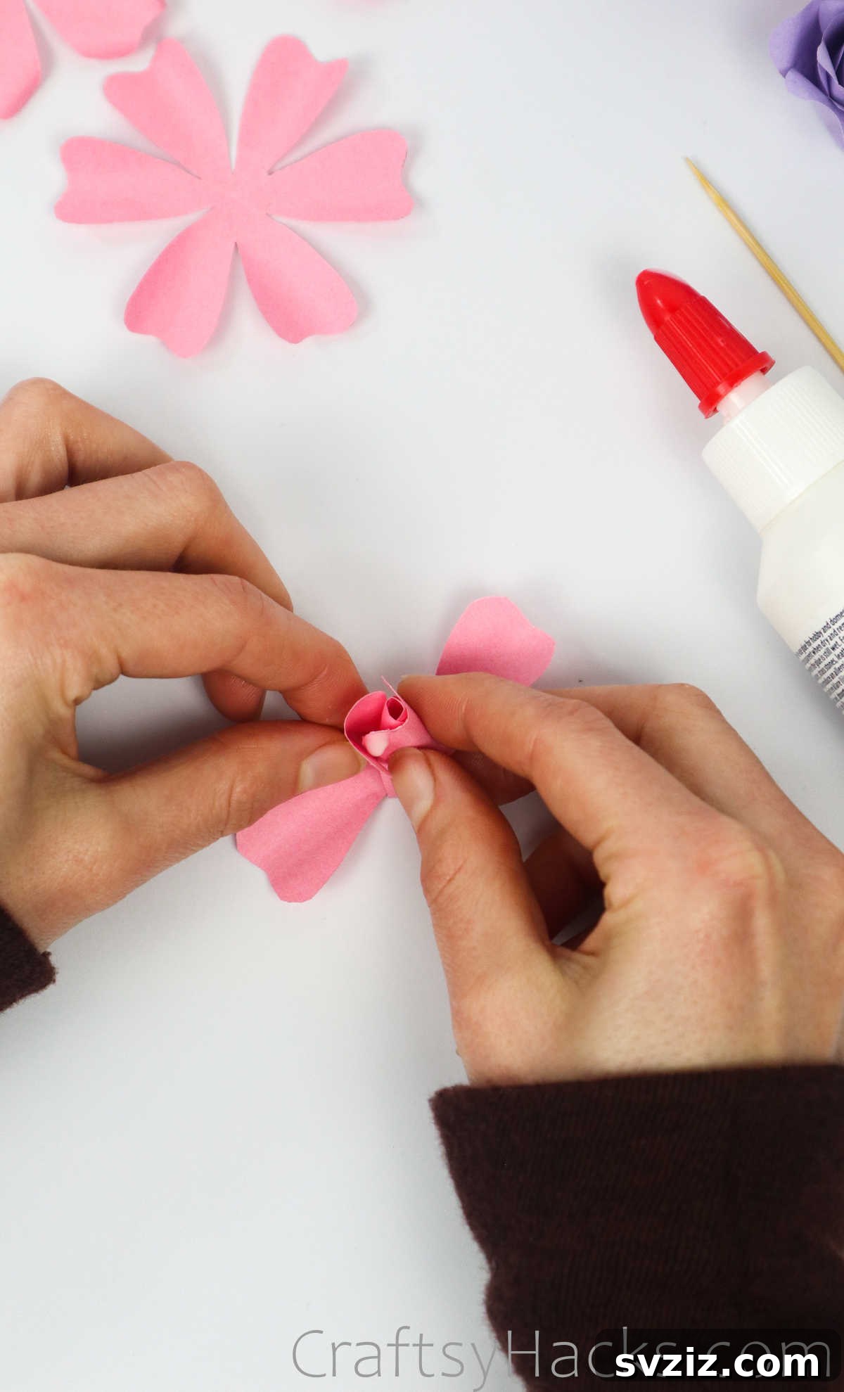 Your Simple Guide to Gorgeous Paper Roses 33 Pressing two more glued petals around the rose bud, creating additional layers