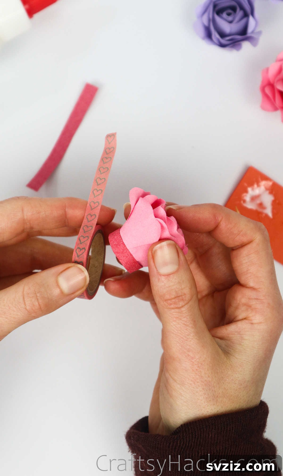 Your Simple Guide to Gorgeous Paper Roses 50 Adding a decorative circle of washi tape to the base of the finished paper rose for a charming touch
