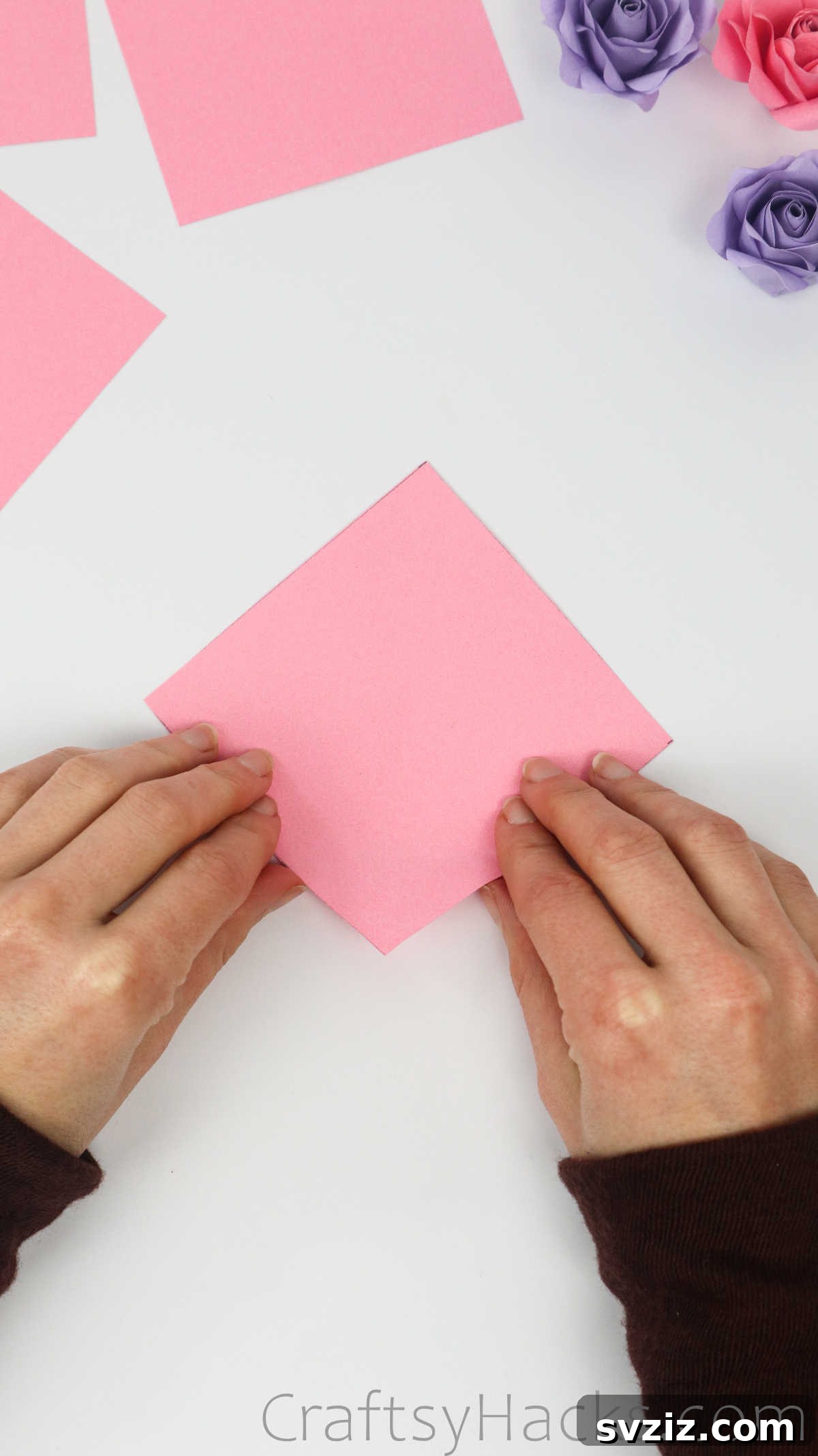 Your Simple Guide to Gorgeous Paper Roses 6 A single pink paper square laid flat on a crafting surface