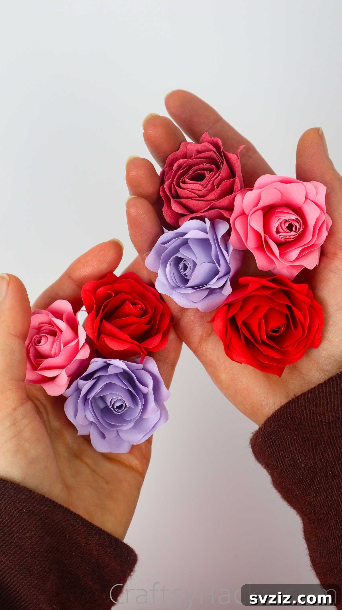 Your Simple Guide to Gorgeous Paper Roses 51 A hand holds several completed DIY paper roses, showcasing their beauty and intricate details