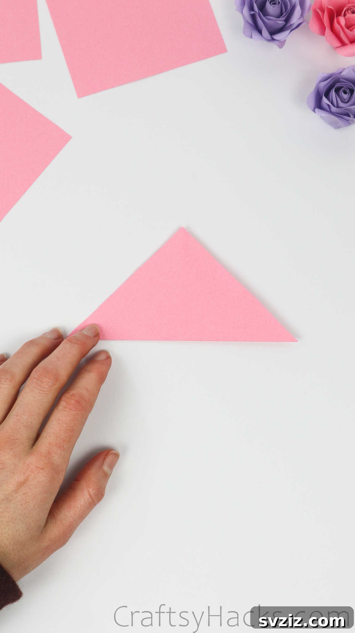 Your Simple Guide to Gorgeous Paper Roses 7 A pink paper square is expertly folded into a triangle