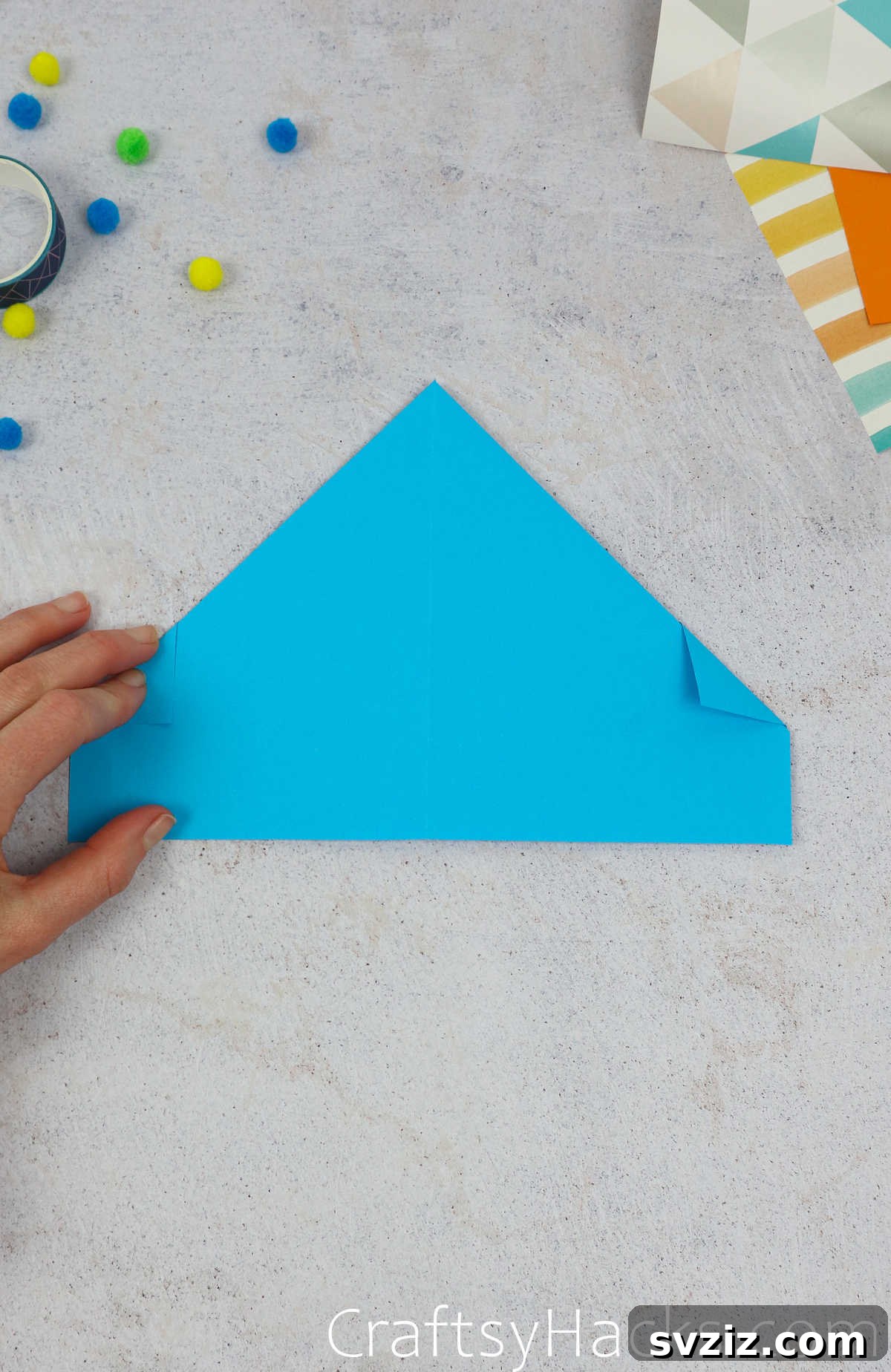 The small triangular corners neatly folded inwards, demonstrating a cleaner edge for the paper hat.
