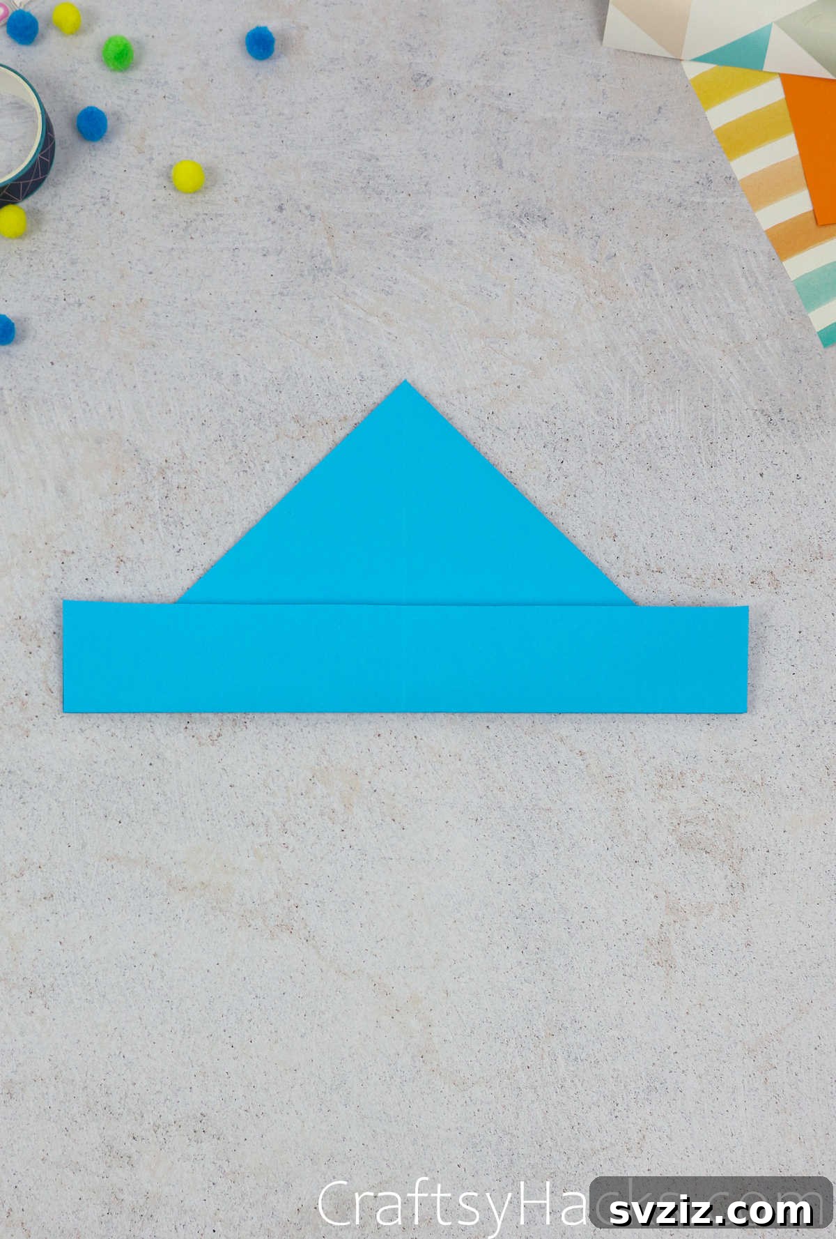 The completed folded bottom brim of the paper hat, showing both layers neatly aligned and secured.