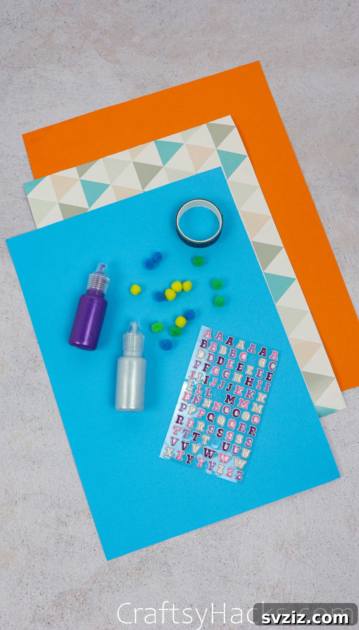 A collection of colorful craft supplies laid out on a table, including pom-poms, washi tape, and letter stickers, ready for paper hat decoration.