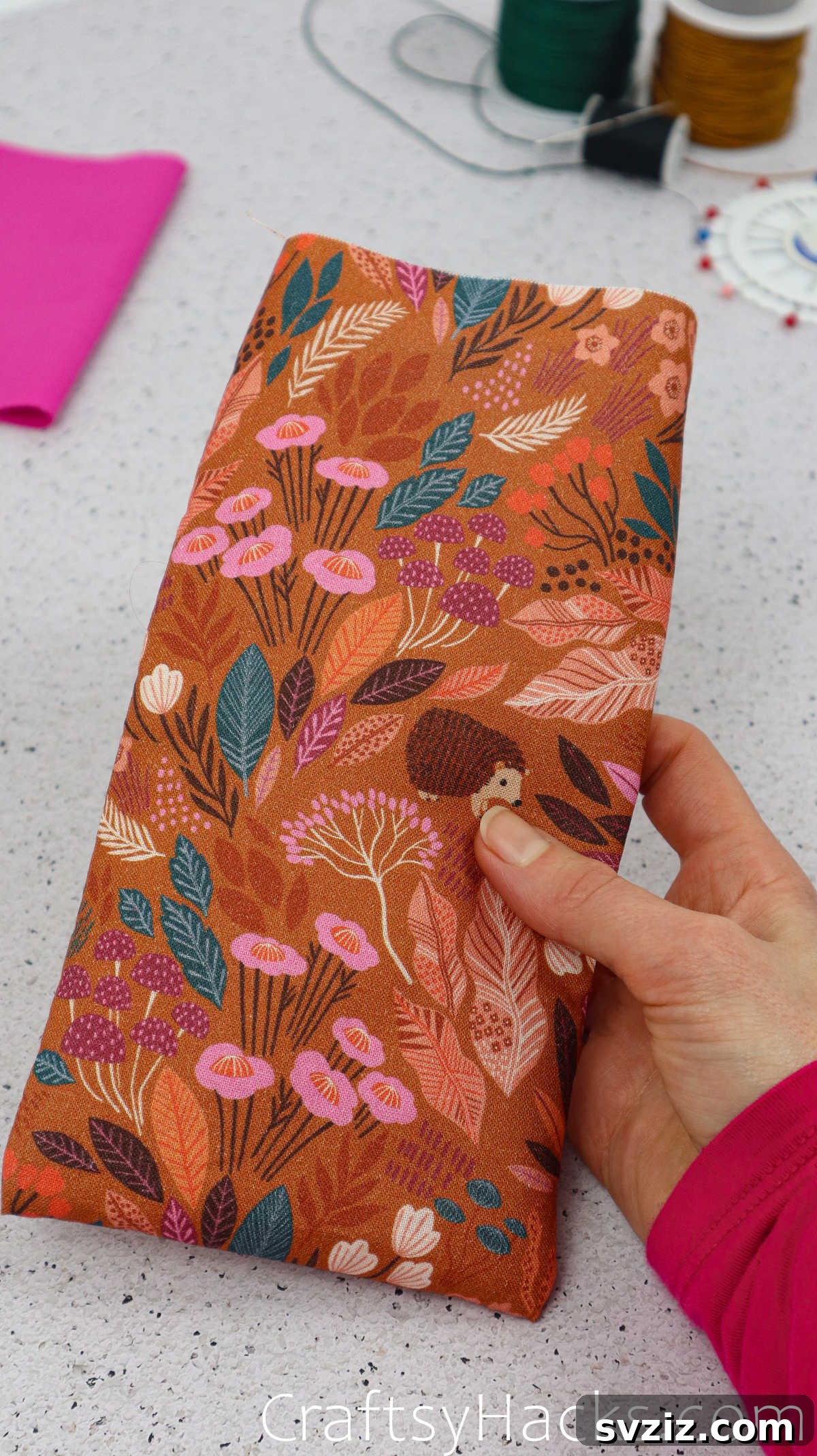 A finished fabric pouch, now right side out, showcasing its shape and ready for the next steps in creating the phone case.