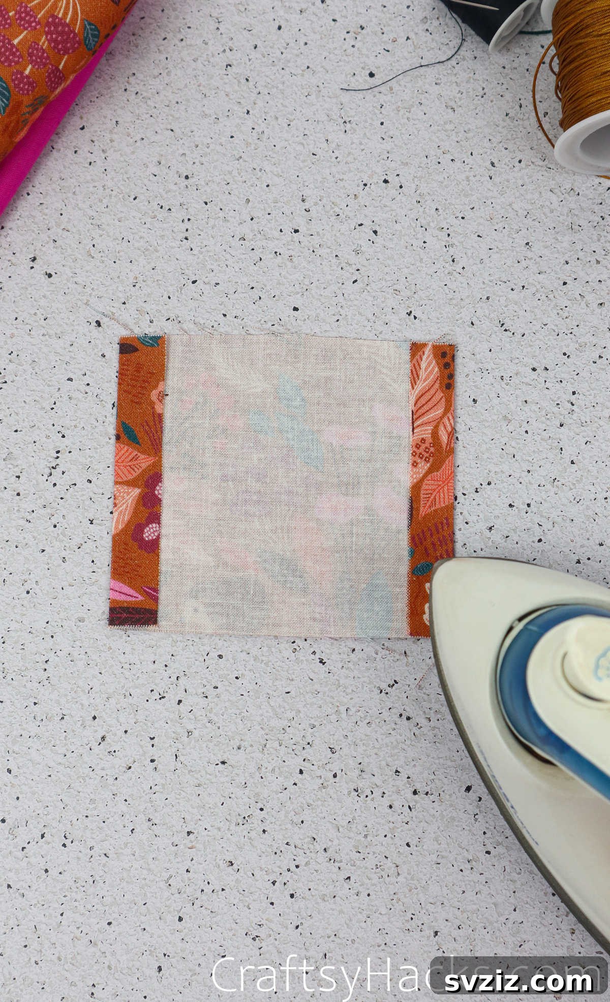 An iron pressing the folded edge of the pocket fabric, creating a crisp seam for a polished finish.