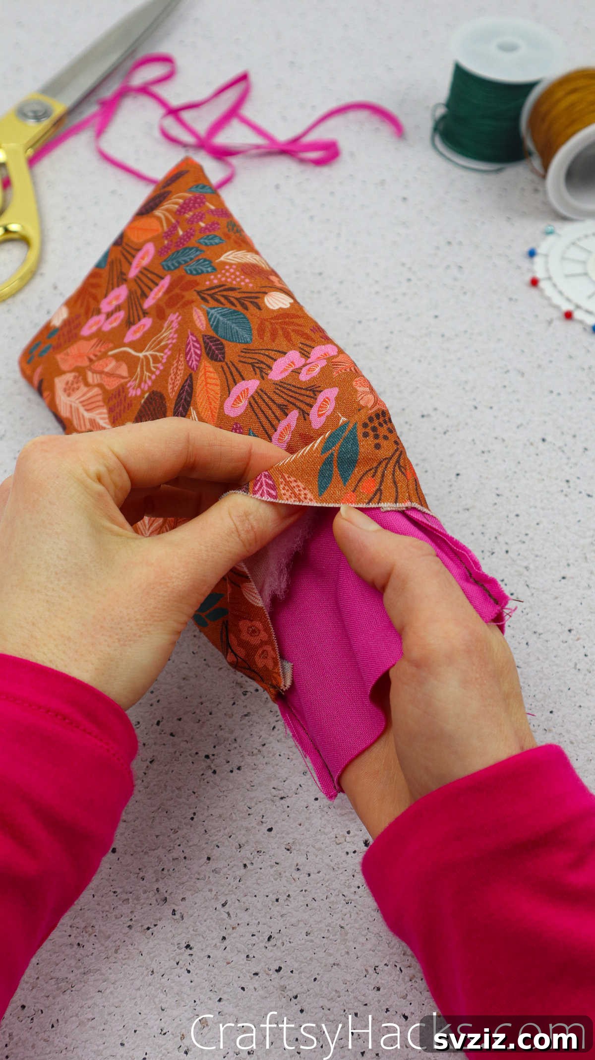 Hands carefully inserting the sewn lining pouch into the main outer fabric pouch, aligning the layers.
